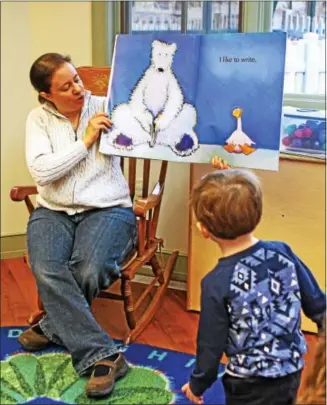 ?? CHRIS BARBER — DIGITAL FIRST MEDIA ?? Avon Grove Library Children’s Librarian Lydia Rehrman shows a picture from the book to a young member of the story time class.