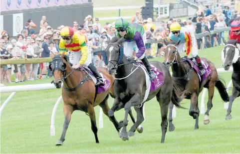  ?? Photo / Trish Dunell ?? Andrew Calder (centre, green and purple) and Back In A Flash winning at Ellerslie on Boxing Day.