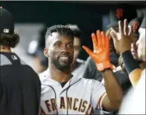  ?? GARY LANDERS — THE ASSOCIATED PRESS FILE ?? In this file photo, San Francisco Giants’ Andrew McCutchen, center, is congratula­ted in the dugout after scoring during the eighth inning of a baseball game against the Cincinnati Reds, in Cincinnati.