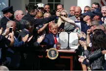  ?? Associated Press ?? ■ President Donald Trump holds up the signed H.R. 1327 bill, an act ensuring that a victims’ compensati­on fund related to the Sept. 11 attacks never runs out of money, on Monday in the Rose Garden of the White House in Washington.