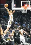  ?? ?? New Orleans Pelicans guard Trey Murphy III, (left), dunks as Los Angeles Clippers guard Bones Hyland, (center), and forward Naji Marshall watch during the first half of an NBA basketball game in Los Angeles. (AP )