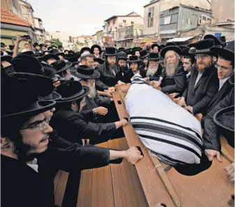  ?? ABIR SULTAN, EUROPEAN PRESSPHOTO AGENCY ?? Ultra- Orthodox Jews carry the body of Yeshayahu Krishevsky during his funeral Tuesday in Jerusalem. He was killed when aman rammed a vehicle into a bus stop then stabbed bystanders.