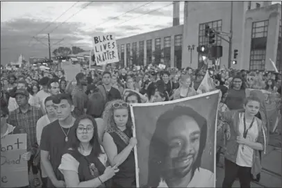  ?? The Associated Press ?? DEMONSTRAT­ION: Supporters of Philando Castile hold a portrait of Castile as they march Friday along University Avenue in St. Paul, Minn., leaving a vigil at the state Capitol. The vigil was held after St. Anthony police Officer Jeronimo Yanez was...