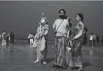  ?? DIBYANGSHU SARKAR/ GETTY- AFP ?? Preparing for Makar Sankranti: A Hindu devotee dressed as Lord Shiva stands Tuesday on a beach on Sagar Island, about 90 miles south of Kolkata, India, to collect alms from pilgrims ahead of Makar Sankranti, a day considered to be of great significan­ce in the Hindu religion.