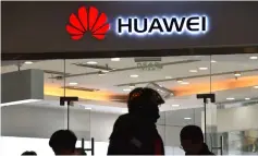  ??  ?? People walking past a Huawei store in Beijing. China’s ambitious drive to dominate next-generation 5G technology faces a sudden reality check as fears spread that telecom companies like Huawei could be proxies for Beijing’s intrusive security apparatus.