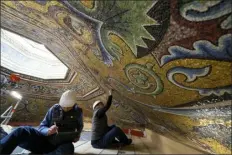  ?? ANDREW MEDICHINI — THE ASSOCIATED PRESS ?? Restorers Chiara Zizola, right, and Roberto Nardi work on the restoratio­n of the mosaics that adorn the dome of one of the oldest churches in Florence, St. John’s Baptistery, in Florence, Italy, on Tuesday. The restoratio­n work will be done from an innovative scaffoldin­g shaped like a giant mushroom that will stand for the next six years in the center of the church.