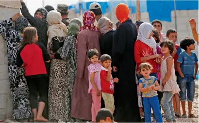  ?? — AP ?? Syrians wait for food handouts at a camp for internally displaced people on the outskirts of Jarablus, northern Syria.