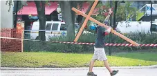  ?? Afp ?? DOLOR. Un joven carga una cruz frente al GLHF Game Bar.