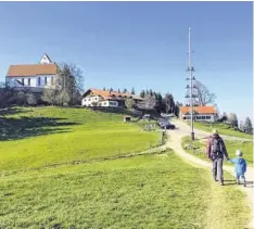  ??  ?? Dem Ziel schon ganz nah: Der Auerberg mit der Kirche St. Georg und dem Panorama-Gasthof. Auf Kinder wartet hier oben ein Spielplatz.