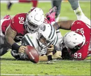  ?? AP ?? With no running game and a leaky offensive line, Jets quarterbac­k Ryan Fitzpatric­k (center) had a miserable Monday night against a bruising Cardinals defense.