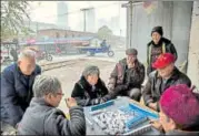  ?? FILE/GETTY IMAGES ?? Elderly people play a game next to the railway tracks in Hebei, just outside Beijing.