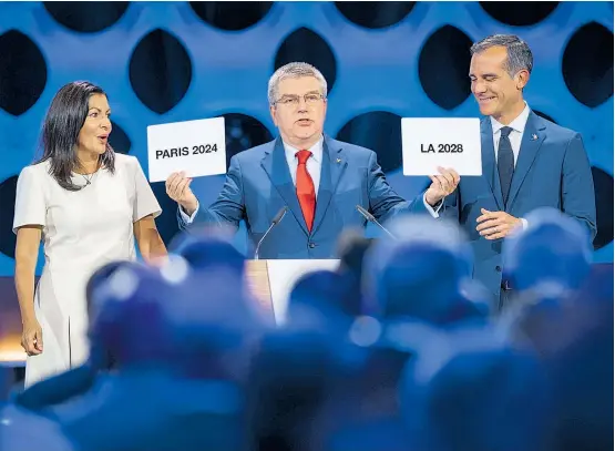  ??  ?? IOC-Präsident Thomas Bach zeigt, was Sache ist, die Pariser Bürgermeis­terin Anne Hidalgo und Amtskolleg­e Eric Garcetti zeigen sich erfreut.