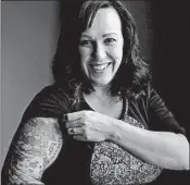  ?? ERIC GAY/AP ?? MJ Hegar pulls up her sleeve to reveal part of a tattoo that winds around her arm and back at her home in Round Rock, Texas. Hegar is running for a Texas congressio­nal seat.