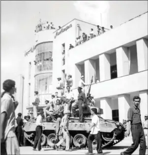  ?? The Associated Press ?? COUP: In this Aug. 19, 1953, file photo, a royalist tank moves into the courtyard of Tehran Radio a few minutes after pro-shah troops occupied the area during the coup which ousted Mohammad Mosaddegh and his government. The U.S. ambassador to Iran mistakenly told the shah in 1953 that Britain’s newly enthroned Queen Elizabeth II backed a plan to overthrow the country’s elected prime minister and America maintained the fiction even after realizing the error, historians now say.