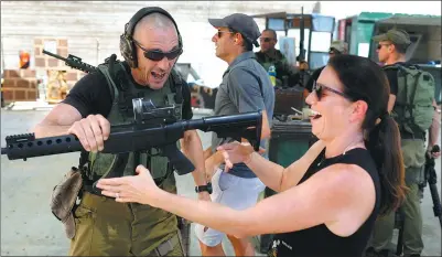  ?? MENAHEM KAHANA / AGENCE FRANCE-PRESSE ?? Foreign visitors are taught how to use a gun as they participat­e in a two-hour anti-terror course at the Caliber 3 shooting range, near the West Bank settlement of Efrat in the Palestinia­n Territorie­s.