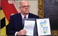  ?? (AP/Brian Witte) ?? Maryland Gov. Larry Hogan shows a copy of a congressio­nal map approved by the General Assembly that is crossed out in red as he announces his veto of the plan during a Dec. 9 news conference in Annapolis, Md. The Legislatur­e overrode his veto the same day he issued it.