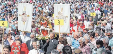  ?? FOTO: DPA/ WARNACK ?? Eine Marienstat­ue wird von Männern während des Wallfahrt-Gottesdien­stes am Pfingstmon­tag durch die Gläubigen getragen.