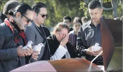  ?? Gary Coronado Los Angeles Times ?? ROSARIO TOVAR BARRAZA, shown with sons, from left, Alex, Gerardo and Armando, cries during her husband’s funeral.