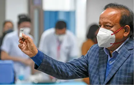  ?? (AFP) ?? India’s Health Minister Harsh Vardhan displays a vial of a COVID-19 vaccine at the All India Institute of Medical Science (AIIMS) in New Delhi on Saturday