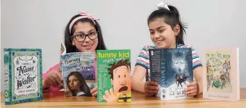  ?? Picture: IAN CURRIE ?? Lola and Penelope Ilton reading some of the books from the Kids Book Club.