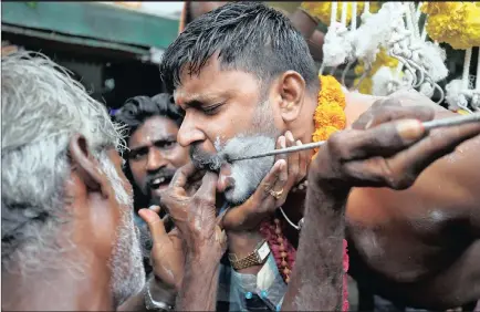  ?? PICTURE: AMIT DAVE / REUTERS ?? A Hindu devotee gets his cheeks pierced with a metal rod as he is suspended from a crane during an annual religious procession called Shitla Mata in Ahmedabad, India, yesterday.