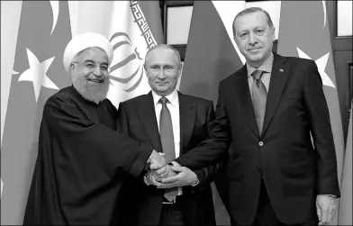  ?? MIKHAIL KLIMENTYEV / KREMLIN VIA AP ?? President of Iran Hassan Rouhani (left), Russian President Vladimir Putin (middle) and Turkish President Recep Tayyip Erdogan shake hands at a meeting in Sochi, Russia, on Wednesday.