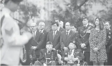  ?? — AFP photo ?? Hong Kong World War II veterans (front row) and attendees, including relatives of WWII veterans, attend the Canadian Commemorat­ive Ceremony honouring those who died during the Battle of Hong Kong and World War II, in Hong Kong’s Sai Wan War Cemetery.