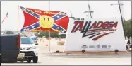  ?? John Bazemore / Associated Press ?? Race fans fly confederat­e flags as they drive by the entrance to Talladega Superspeed­way on Sunday.