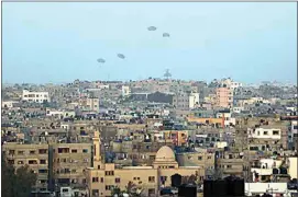  ?? MOHAMMED HAJJAR / AP ?? Humanitari­an aid is dropped by the United States Saturday over Gaza City, Gaza Strip.