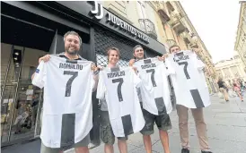  ??  ?? Fans hold Juventus’ shirts with Ronaldo’s name and number.