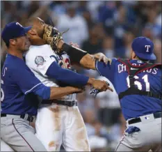  ?? AP PHOTO/JAE C. HONG ?? Texas Rangers starting pitcher Cole Hamels (left) restrains Los Angeles Dodgers’ Matt Kemp as Kemp scuffles with Rangers catcher Robinson Chirinos during the third inning of a baseball game Wednesday in Los Angeles.