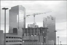  ?? AMANDA MCCOY/FORT WORTH STAR-TELEGRAM ?? A crane can be seen atop what will be Deco 969, the apartment tower under constructi­on in downtown Fort Worth, on Dec. 6, 2022. Deco 969 will have 27 stories of luxury apartments.