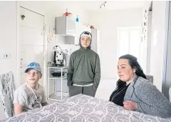  ??  ?? Angela Esposito, right, and her two sons Francesco Saturno, centre, and Angelo at home in Ponticelli, Naples.