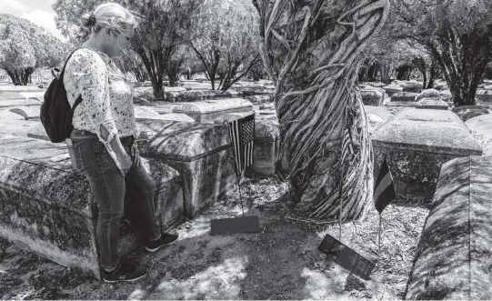  ?? JOSE A. IGLESIAS jiglesias@elnuevoher­ald.com ?? Retired Miami Detective Jerry Lynn Dellamico stands over makeshift memorials for City of Miami Officer Johnnie Young, right, and Metro Dade Officer Simmons Arrington at Evergreen Memorial Park in Allapatah.