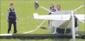  ?? .*5$) ."$%0/"-% 5)& (6"3%*"/ ?? RCMP officers look over the scene of a plane that crash-landed in Hampton due to engine failure on Sunday afternoon. Police said the pilot reported the plane was flying at about 2,000 feet altitude when the engine began to fail.