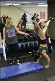  ?? JOHN RAOUX — THE ASSOCIATED PRESS ?? Associated Press writer Jenna Fryer, left, watches as Danica Patrick does a hand stand during a workout at Daytona Internatio­nal Speedway, in Daytona Beach, Fla.