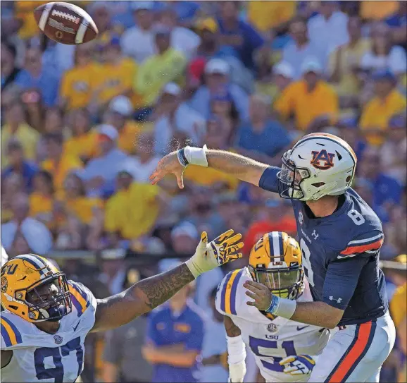  ??  ?? Auburn quarterbac­k Jarrett Stidham (8) throws against LSU defensive end Frank Herron (97) and linebacker Jonathan Rucker (51) during last season’s matchup in Baton Rouge, La., Oct. 14, 2017. [MATTHEW HINTON/THE ASSOCIATED PRESS]