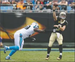  ?? The Associated Press ?? UNDER PRESSURE: New Orleans Saints’ Drew Brees (9) throws a pass while being pressured by Carolina Panthers’ Kawann Short (99) in the first half of Sunday’s game in Charlotte, N.C.