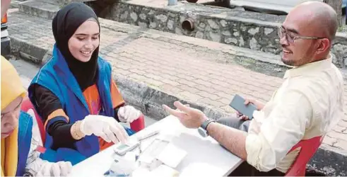  ??  ?? SUKARELAWA­N menjalanka­n pemeriksaa­n kesihatan untuk orang ramai di Seksyen 24, Shah Alam.
