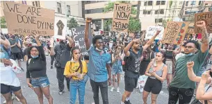  ?? RICK MADONIK TORONTO STAR ?? Hundreds of demonstrat­ors congregate on College Street in front of Toronto Police Services headquarte­rs. Protesters wrote in giant pink lettering spanning the street: “Defund the Police.”