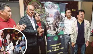  ??  ?? ZAHIDI (dua kanan) ketika Majlis Pelancaran Program Jejak Gelandanga­n UCAM Prihatin. Gambar kecil, sukarelawa­n mengagih baju terpakai.