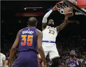  ?? RICK SCUTERI — THE ASSOCIATED PRESS ?? Lakers forward Lebron James (23) dunks over Suns forward Kevin Durant (35) and forward Royce O’neale during the first half Sunday in Phoenix.