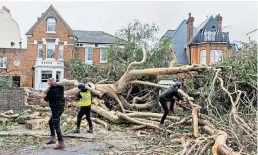  ?? ?? Clockwise from bottom left, inset: Dominic Good with the 400-year-old oak uprooted from his garden near Brentwood, Essex, that crashed into his house (main picture); tree surgeons make safe the remains of a tree in Battersea, south London; a chimney collapsed on the Isle of Grain, Kent, forcing the power plant’s closure; a roof was blown off a block of flats in South Wimbledon