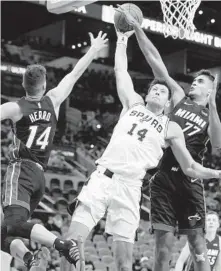  ?? ?? The Spurs’ Drew Eubanks, center, attempts to shoot against the Heat’s Omer Yurtseven, right, and Tyler Herro during the second half Friday in San Antonio.
DARREN ABATE/AP