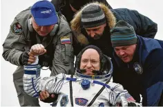  ?? Associated Press file photo ?? Scott Kelly is helped out of Soyuz space capsule after 2016 landing.
