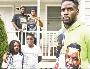  ?? Peter Hvizdak / Hearst Connecticu­t Media ?? The family of Mubarak Soulemane stand in front of their New Haven home on Friday. Mubarak Solulemane was fatally shot by a state trooper near Interstate 95 off of exit 43. Standing on the porch, right rear is the mother of Mubarak Soulemane, Omo Mohammed. Mubarak’s siblings from left rear to right: Mariyann Soulemane; Sirah Bandeh, 9; Ishamel Bandeh, 13; and Saeed Soulemane, 19, who wears a hoodie with an image of himself and his brother Mubarak.