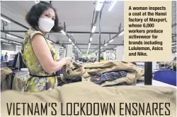  ?? ?? A woman inspects a coat at the Hanoi factory of Maxport, whose 6,000 workers produce activewear for brands including Lululemon, Asics and Nike.