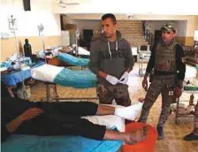  ?? AFP ?? Iraqi soldiers tend to a civilian who was injured by Daesh terrorists at a school-turned-hospital in western Mosul, on Friday.