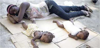  ?? AP ?? In this November 24, 2013, file photo, Marie Matte Mayan, 26, sleeps on the floor with her twins, Maudeline and Maudena Pierre, at a shelter in Croix-des-Bouquets, Haiti, after being deported by Dominican Republic authoritie­s. Caribbean countries have...