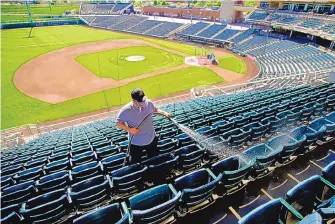  ?? ADOLPHE PIERRE-LOUIS/JOURNAL ?? Groundskee­per Daniel Gallegos washes seats on Wednesday in preparatio­n for Thursday’s Albuquerqu­e Isotopes opener. The last Isotopes game was on Aug. 29, 2019.